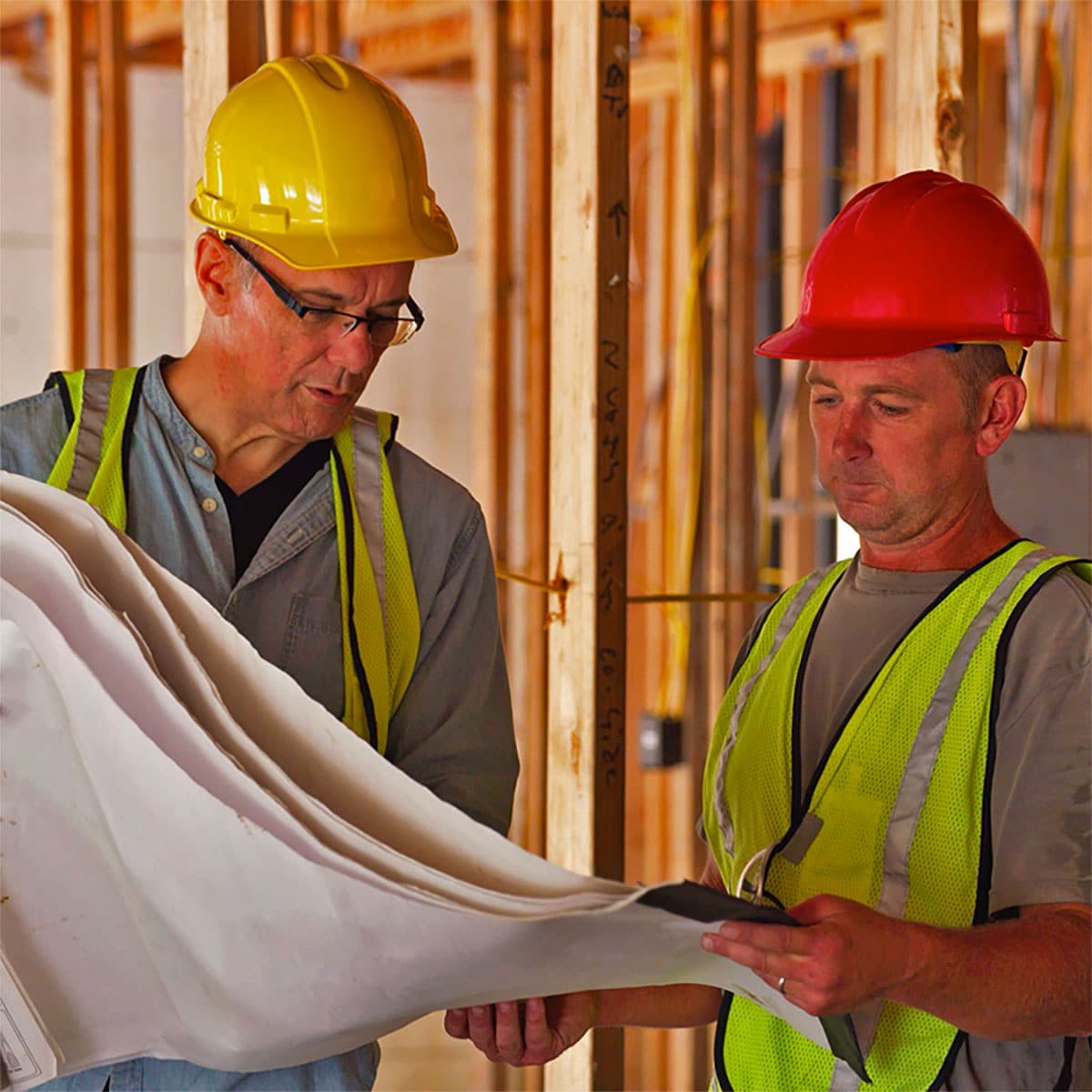 Electrical contractors discuss plans in a new construction home.